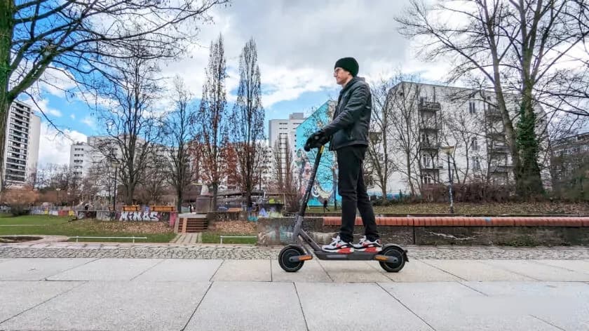 xiaomi electric scooter 4 ultra ridden by a man side on